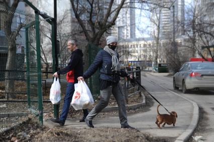 Екатеринбург. Женщина в медицинской маске гуляет с собакой во время нерабочей недели объявленной президентом РФ для снижения темпов распространения коронавируса COVID-19