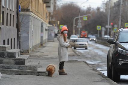 Екатеринбург. Девушка в медицинской маске гуляет с собакой во время нерабочей недели объявленной президентом РФ для снижения темпов распространения коронавируса COVID-19