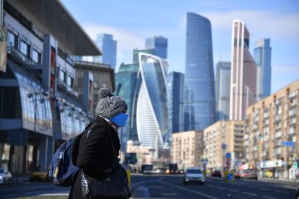 Москва.  Женщина в медицинской маске на улице города.