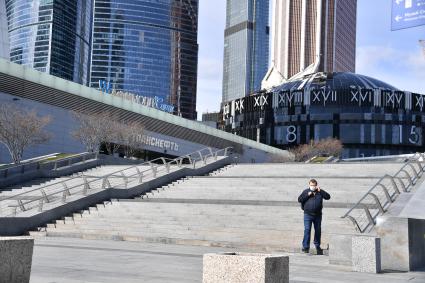 Москва.  Мужчина в медицинской маске  у Делового центра Москва-Сити.