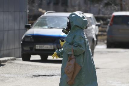 Барнаул. Женщина в плаще ОЗК и противогазе на улице.