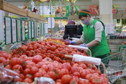 Красноярск. Сотрудница продуктового магазина выкладывает товар на прилавок.