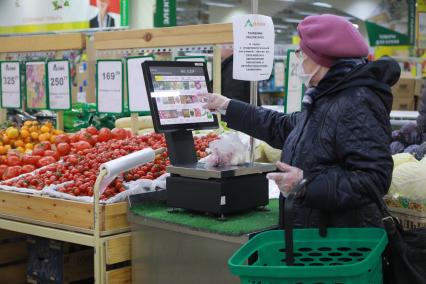 Красноярск. Женщина в медицинской маске в продуктовом магазине.