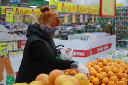 Красноярск. Женщина в медицинской маске в продуктовом магазине.