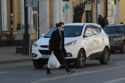 Иркутск. Мужчина в медицинской маске на улице города.