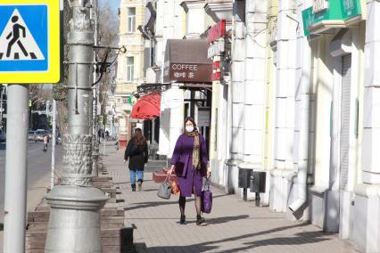 Иркутск. Женщина в медицинской маске на улице города.