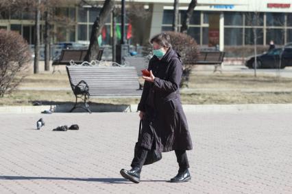 Иркутск. Женщина в медицинской маске на улице города.