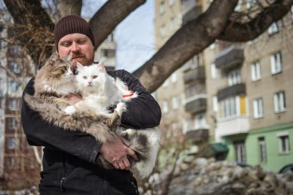 Новосибирск.  Мужчина держит на руках кошек.