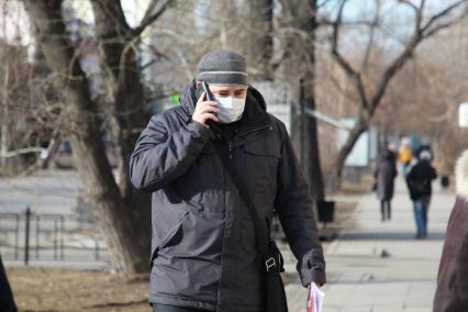Иркутск.  Мужчина в медицинской маске на улице.