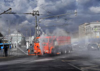 Москва. Распылительная и поливомоечная техника во время дезинфекции проезжей части у метро Белорусская.