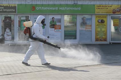 Барнаул. Сотрудник коммунальной службы в защитном костюме во время дезинфекции улиц.