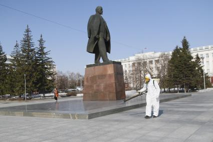 Барнаул. Сотрудник коммунальной службы в защитном костюме во время дезинфекции улиц.