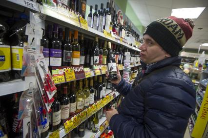 Екатернбург. Мужчина выбирает вино в отделе алкогольных напитков продуктового магазина