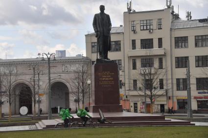 Москва. Сотрудники сервиса доставки еды на улице города.