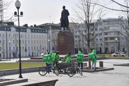 Москва. Сотрудники сервиса доставки еды в сквере площади Тверская застава.