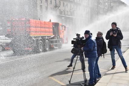 Москва. Фотокорреспонденты фотографируют  проведение дезинфекции на улицах города.