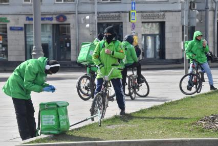 Москва. Сотрудники сервиса доставки еды на улице города.