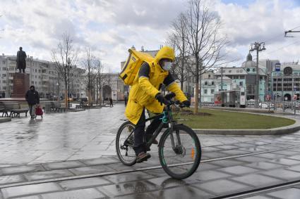 Москва. Сотрудники сервиса доставки еды на улице города.