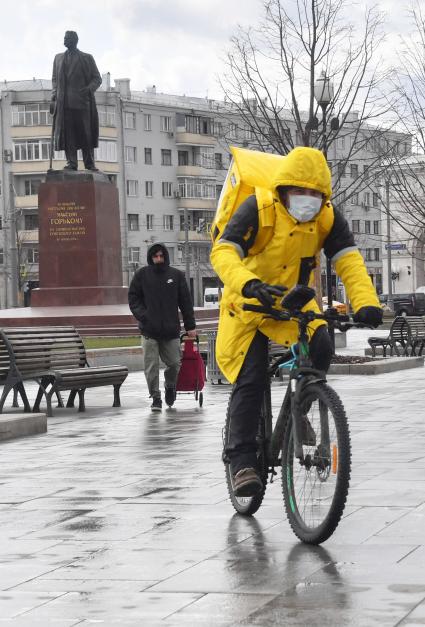 Москва. Сотрудники сервиса доставки еды на улице города.