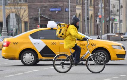 Москва. Сотрудник сервиса доставки еды на улицах города.