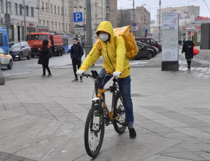 Москва. Сотрудники сервиса доставки еды на улице города.