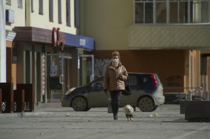 Екатеринбург. Женщина в медицинской маске гуляют с собакой во время нерабочей недели объявленной президентом РФ для снижения темпов распространения коронавируса COVID-19