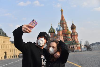 Москва.  Молодые люди в медицинских масках  на Красной площади.