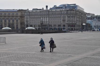 Москва.  Женщины в медицинских масках на Манежной площади.