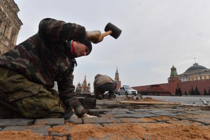 Москва. Рабочий во время замены брусчатки на Красной площади.