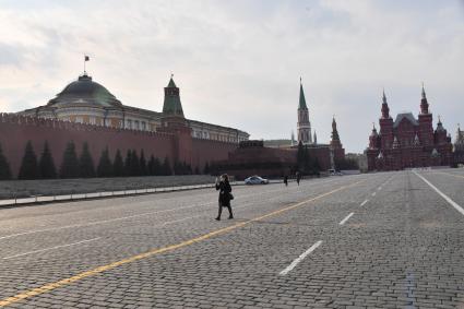 Москва.  Девушка в медицинской маске на Красной площади.