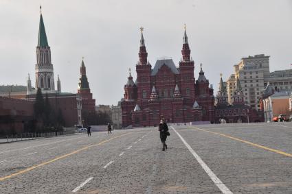 Москва.  Девушка в медицинской маске на Красной площади.