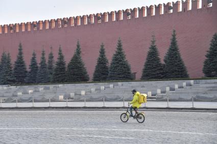 Москва.  Сотрудник сервиса по доставке еды `Яндекс.Еда` на Красной площади.