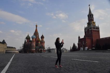 Москва.  Девушка в медицинской маске на Красной площади.