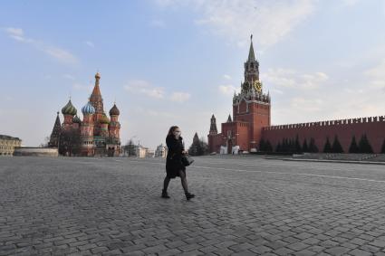 Москва.  Девушка в медицинской маске на Красной площади.