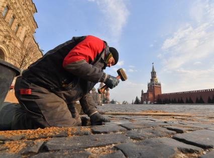 Москва. Рабочий во время замены брусчатки на Красной площади.