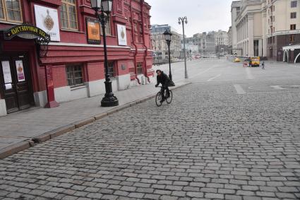 Москва. Мужчина на велосипеде на Манежной площади.