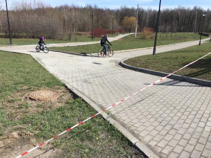 Москва. Отдыхающие гуляют в закрытом  для посещения парке.