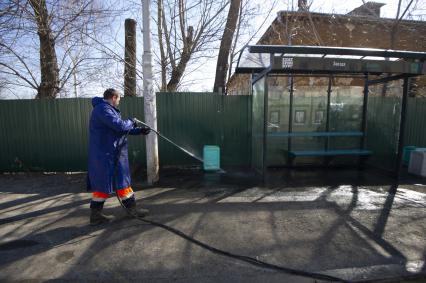 Екатеринбург. Рабочие моет остановку общественного транспорта дезинфицирующим раствором \'Дэо-хлор\' Коммунальная уборочная техника во время приемки ее готовности к работе по уборке улиц города