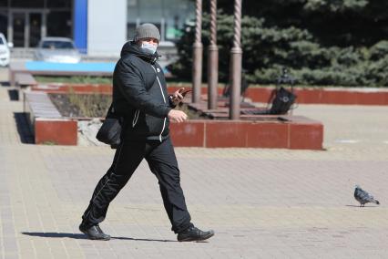 Красноярск.  Мужчина в медицинской маске на улице.