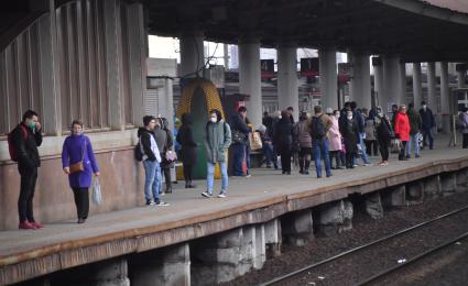 Москва.  Пассажиры на платформе пригородных поездов.