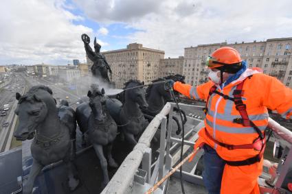 Москва. Сотрудник коммунальной службы моет Триумфальную арку на Кутузовском проспекте.