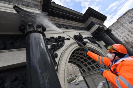 Москва. Сотрудник коммунальной службы моет Триумфальную арку на Кутузовском проспекте.