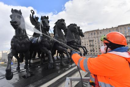 Москва. Сотрудник коммунальной службы моет Триумфальную арку на Кутузовском проспекте.