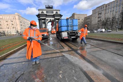 Москва. Сотрудник коммунальной службы моют территорию у Триумфальной арки на Кутузовском проспекте.