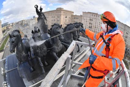 Москва. Сотрудник коммунальной службы моет Триумфальную арку на Кутузовском проспекте.