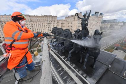 Москва. Сотрудник коммунальной службы моет Триумфальную арку на Кутузовском проспекте.