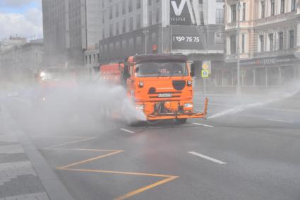 Москва.   Автомобили коммунальной службы моют улицу.