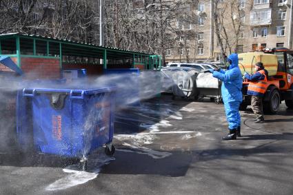 Москва.  Сотрудник коммунальной службы в защитном костюме во время дезинфекции улиц.