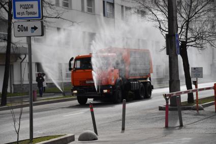 Москва.   Автомобиль коммунальной службы моет улицу.