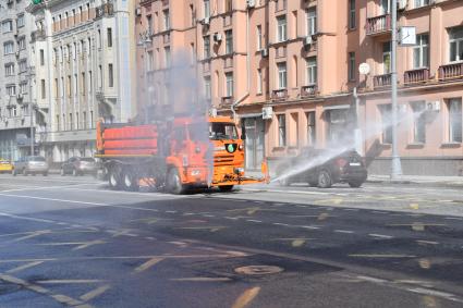 Москва.   Автомобиль коммунальной службы моет улицу.